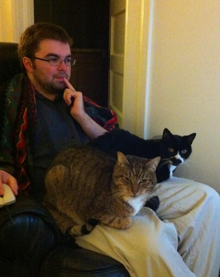 Me sitting on a lazy boy chair with cats Flip (left), and Tip (right) sitting on the chair arms.